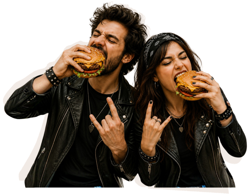 Pareja con estilo rockero comiendo hamburguesas y haciendo el gesto de cuernos